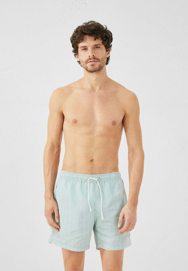 Pantaloni da bagno a righe blu chiaro con elastico in vita e coulisse. Presentano tasche laterali e una vestibilità comoda.