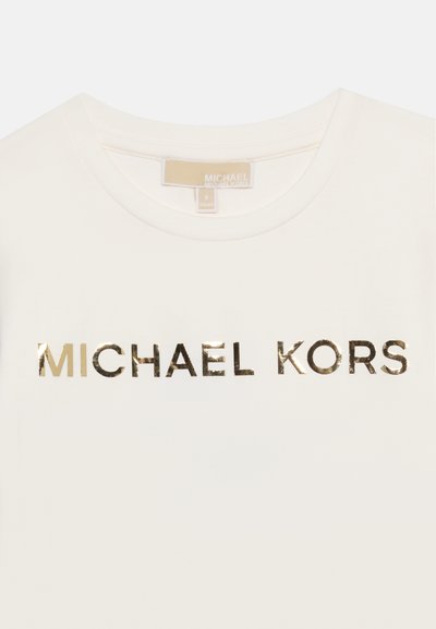 Λευκό t-shirt με στρογγυλή λαιμόκοψη και λαμπερό χρυσό λογότυπο "MICHAEL KORS" τυπωμένο στο στήθος, καθώς και μπεζ ετικέτα της μάρκας στο εσωτερικό του λαιμού.