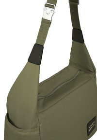 Khaki grønn skulderveske med en glidelåsrom, justerbar stropp og svarte detaljer. Har en sydd merkevarelogo.