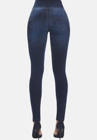 Cienkie dżinsy w ciemnoniebieskim denimu z wysokim stanem, pięcioma kieszeniami i subtelnymi detalami przeszycia. Gładka tekstura i dopasowany kształt.