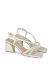 Witte sandalen met blokhak en strappen, met een vierkante neus, met een glanzende accent op de hak en een gesp sluiting. Gladde oppervlakte textuur.