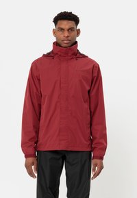 Burgundská, voděodolná bunda s vysokým límcem a nastavitelnou šňůrkou. Obsahuje přední zip a elastické manžety, spárované s černými kalhotami.