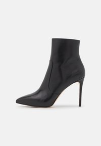Stivale alla caviglia in pelle nera con punta affusolata, finitura liscia, panello elastico laterale e tacco a stiletto alto. Design minimalista.