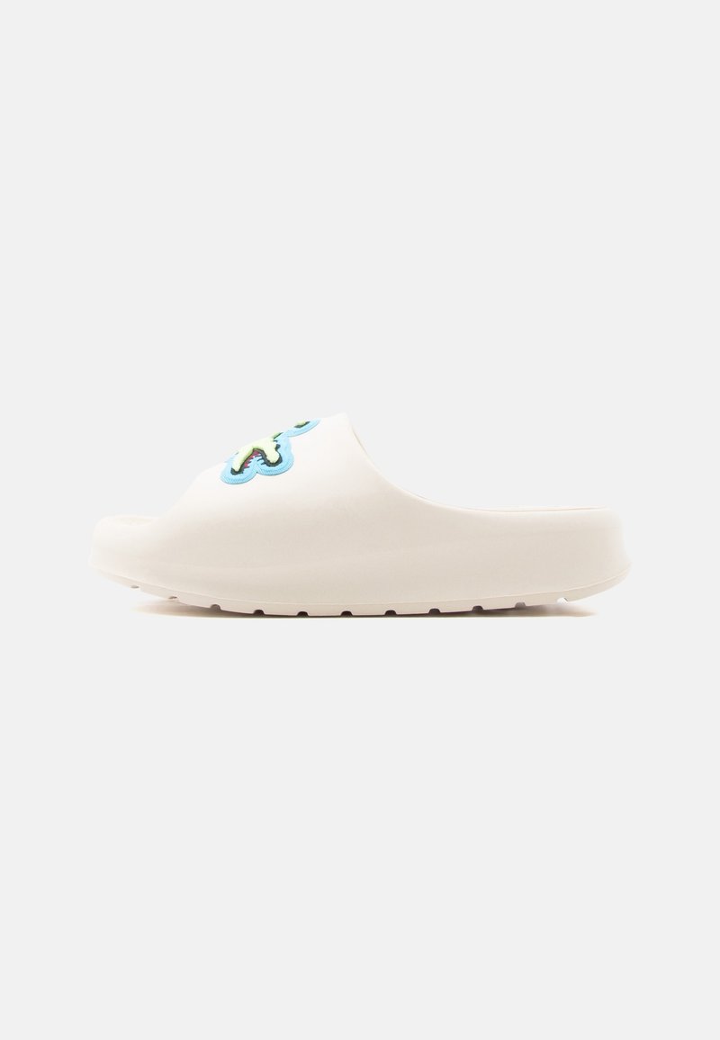 Sabot blanc à enfiler avec un patch décoratif bleu et vert sur la tige, doté d'une semelle épaisse et d'un bout arrondi.