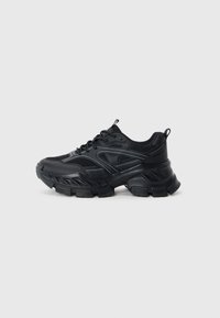 Black athletic shoes with a mesh upper and synthetic overlays, featuring a thick, textured sole with a distinctive tread pattern.