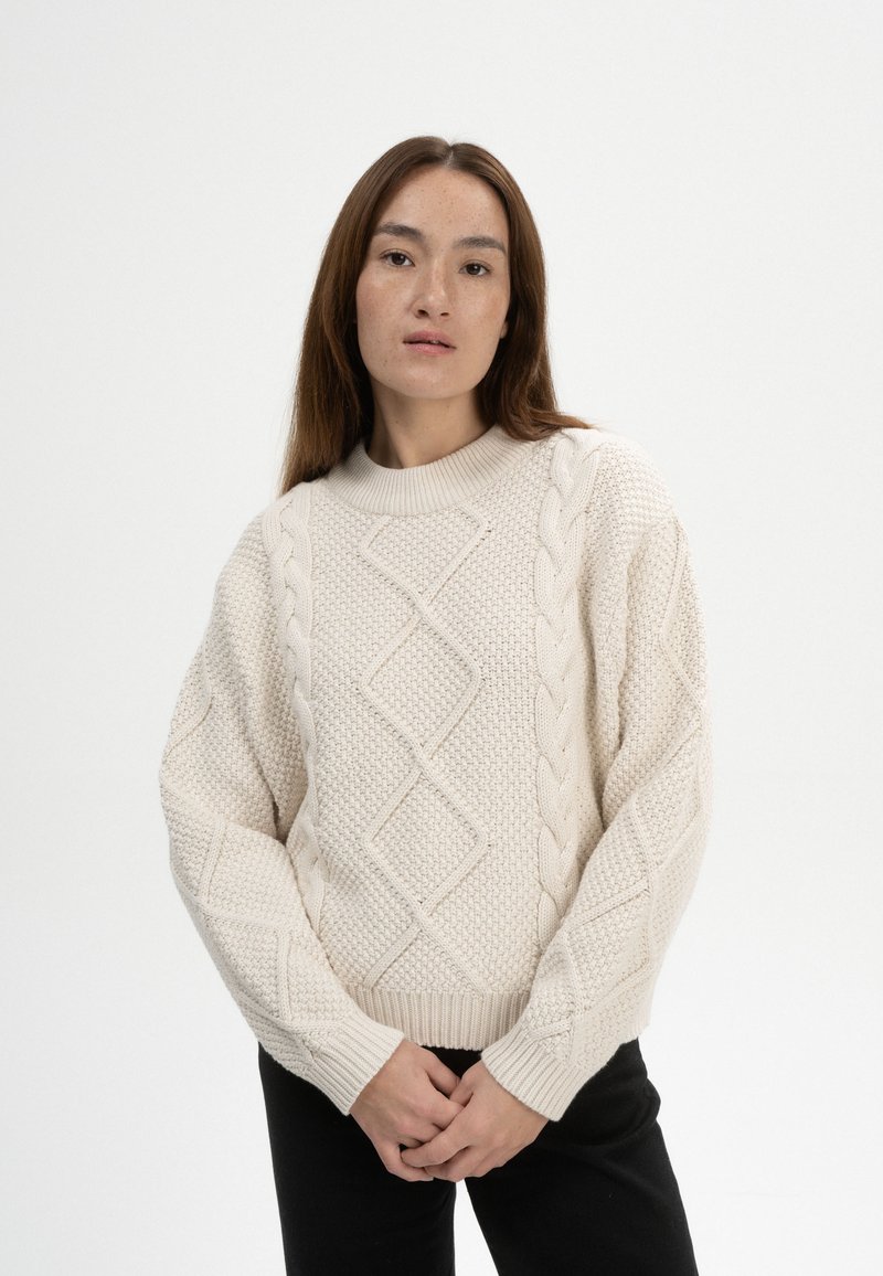 Cremefarbene Strickjacke mit erhobenen Zopfmustern und einem strukturierten Diamantdesign, mit gerippten Bündchen und Saum.