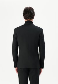 Black blazer with a structured fit, featuring a single vent, notched lapels, and buttoned cuffs. Smooth fabric with a polished finish.