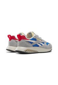 Un par de zapatillas deportivas grises, azules y rojas con suelas blancas y detalles en la mediasuela con patrón de panal, vistas desde la parte trasera y lateral.