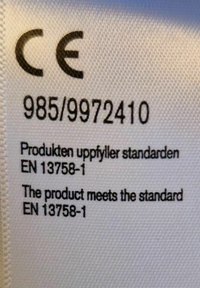 CE-märkning med svart text på vit tygbakgrund. Innehåller produktnummer 985/9972410 och standarderna EN 13758-1 på flera språk.