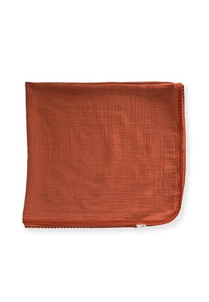 Rustfarvet blødt stofkvadrat foldet med synlig struktur og en lille hvid mærkat i bunden mod en hvid baggrund.