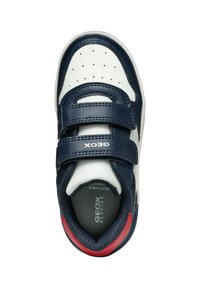 Marinblå och vit sneaker med perforerat mönster, två kardborreband, röd accent på hälen och en ventilerande meshfoder.