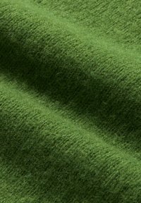 Grüner Wollstoff mit einer strukturierten, gestrickten Musterung, die weiche Fasern und einen reichen, tiefen Farbton zeigt. Glatte und leicht fuzzy Oberfläche.