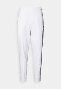 Witte sweatpants met een taps toelopend ontwerp, elastische tailleband en afgewerkte randen. Heeftzijnaadse en een klein zwart logo aan de voorkant.