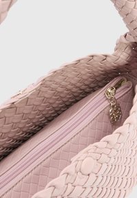Geweven roze handtas met een ritsvak aan de binnenkant, een gladde binnenvoering en een drukknoopsluiting. Getextureerde buitenkant met gevlochten details.