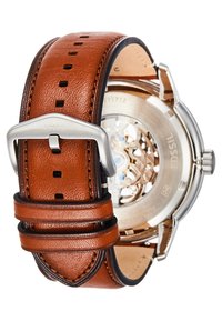 Bruin leren horloge band met gestikte details, zilveren metalen gesp en transparante achterkant die het complexe ontwerp van de beweging onthult.