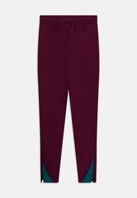 Bordeauxkleurige sportbroek met een elastische tailleband, taps toelopend ontwerp en turquoise accenten bij de ritsen op de enkels. Glad stoftextuur.