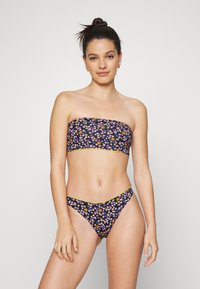 Conjunto de biquíni floral com top bandeau e fundo correspondente. Base preta com padrões de flores multicoloridas, detalhes amarelos e um design ajustado.