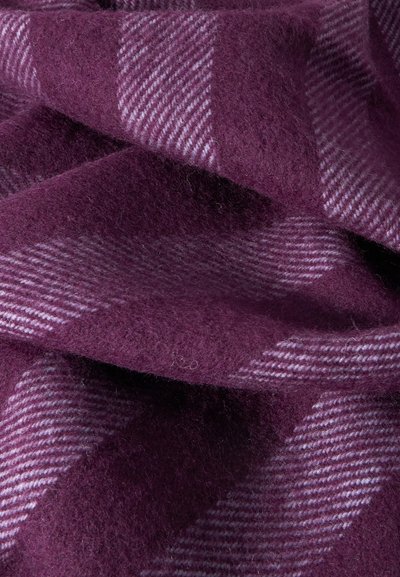 Μαλακό, παχύ μάλλινο ύφασμα σε σκούρο μοβ με πιο ανοιχτό μοβ καρό σχέδιο, εμφανιζόμενο σε κοντινή λήψη με πτυχώσεις και λεπτομέρειες υφής.