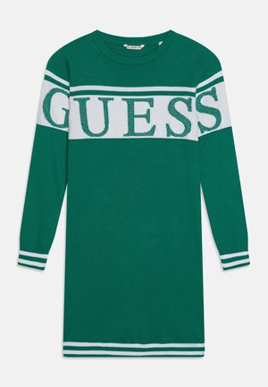 Robe pull en tricot vert avec un logo "GUESS" blanc sur la poitrine, comportant des accents rayés blancs aux poignets et à l'ourlet.