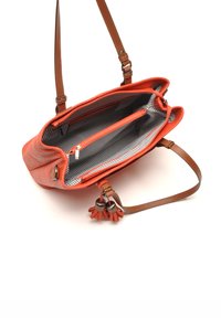 Oranje leren handtas met een gestreepte binnenkant, een ritsvak en een decoratieve kwast. Verstelbare bruine schouderbanden met hardwareaccenten.