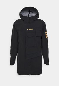 Veste imperméable noire avec fermeture éclair à l'avant, capuche ajustable, plusieurs poches et un logo Terrex distinctif avec des accents de trois rayures.