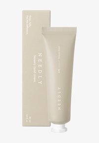 Beige tub av NEEDLY sensorisk handkräm med ett vitt lock, placerad bredvid en matchande beige låda med text som anger produktinformation.
