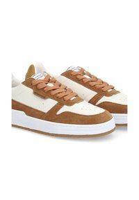 Weiße und braune Sneaker aus Wildleder und Leder, mit braunen Schnürsenkeln, perforiertem Zehenbereich und einer weißen Sohle.