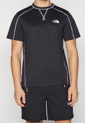 Schwarzes sportliches Kurzarmshirt mit weißen Nähten und The North Face-Logo auf der Brust, getragen mit schwarzen Shorts mit Seitentaschen.