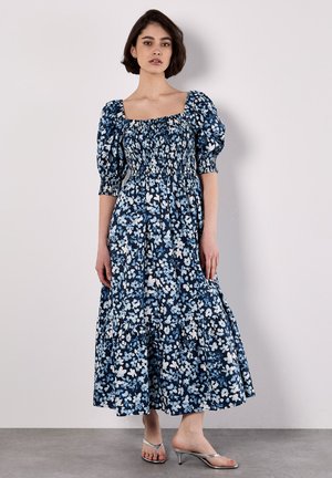 Blumen-Maxikleid in Dunkelblau und Weiß, mit Puffärmeln, einem gerafften Oberteil und einem gestuften unteren Saum für mehr Volumen.