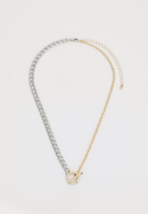 Collier en métal composé d'une chaîne argentée entrelacée avec une chaîne dorée, mettant en avant un fermoir rond au centre.