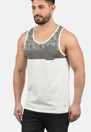Graues und weißes Tanktop mit floralem Muster im oberen Bereich, einer vorderen Tasche und lockerer Passform. Hergestellt aus leichtem Material.