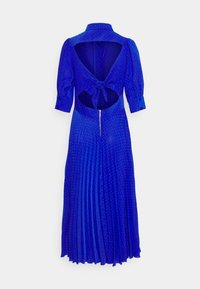 Blå plisserad klänning med krage, öppen rygg och knytdetalj. Har prickig textur och dragkedja i midjan.