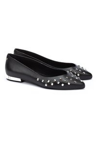 Bailarinas de piel negra con punta afilada, decoradas con tachuelas metálicas y un pequeño detalle de tacón metálico. Textura suave con detalles brillantes.