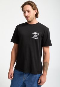 Czarny bawełniany t-shirt z krótkim rękawem, z białym graficznym napisem i wzorem na lewej piersi. Casualowy krój, gładka tekstura.