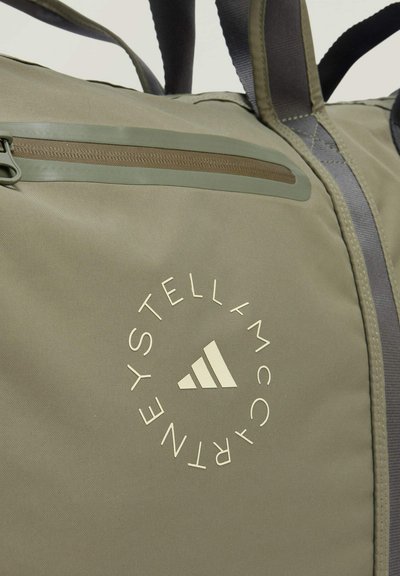 Maslinasto zelena torba na remen s glatkom tkaninom, koja ima horizontalnu zip džep, logo otisnut u krem boji i sivo podešljive trake.
