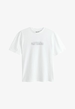 White short-sleeve crew neck t-shirt with small centered text "By Order of the Peaky Blinders" in a classic serif font.