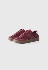 Maroon sneakers made of suede and leather, featuring a round toe, stitched accents, and a brown rubber sole with brand lettering.