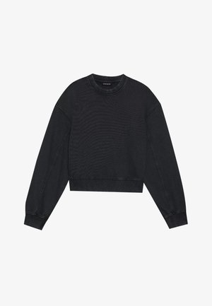 Svart kortermet genser med lange ermer, rund hals og ribbet kant. Jevn tekstur med synlige sømdetaljer.
