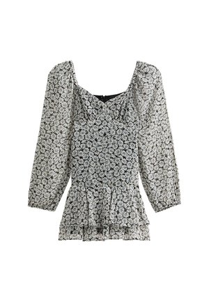 Svart och vit blommig blus med puffärmar, volangkant i midjan och rundad halsringning. Lättviktig tyg med en delikat textur.