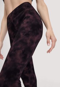 Zwarte en donkerpaarse tie-dye legging met een hoge tailleband en een gladde textuur, met een aansluitend ontwerp en platte naden.