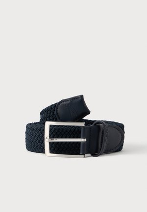 Ceinture noire tissée avec une boucle rectangulaire argentée et des extrémités en cuir, enroulée soigneusement sur un fond blanc uni.