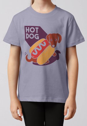 Enfant portant une chemise lavande avec un graphique d'un chien teckel dans un pain hot dog et le texte "HOT DOG."