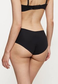 Mutande nere a vita alta realizzate in un tessuto morbido e elastico. Presentano una cintura larga e cuciture minime per un aspetto senza soluzione di continuità.