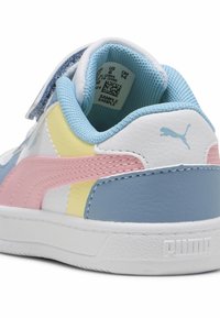 Sneakers PUMA z białą skórzaną cholewką z niebieskimi, różowymi i żółtymi akcentami. Zapięcie na rzepy oraz teksturowana gumowa podeszwa.