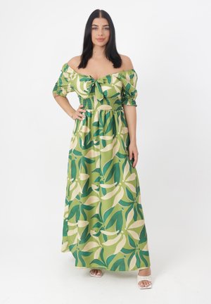 Robe maxi verte avec design décolleté, dotée d'un lien à l'avant, taille smockée et motifs de feuilles audacieux dans des nuances variées de vert et de crème.