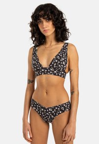 Svart blommig bikinitopp med djup V-ringning och lågt skurna bottnar, tillverkad av mjukt tyg med en slät yta och delikat mönster.