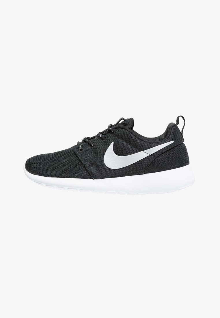 Chaussure de course Nike noire avec logo swoosh blanc, semelle blanche, tige en mesh, lacets noirs et languette au talon, vue de côté sur fond blanc.