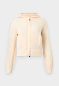 Εκρού πλεκτή ζακέτα με φερμουάρ, μακριά μανίκια, ριμπ μανσέτες και δύο μπροστινές τσέπες, παρουσιασμένη σε απλό φωτεινό φόντο.