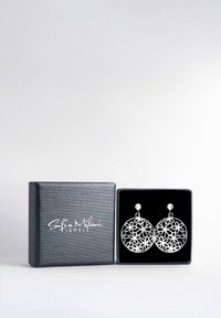 Silberne Filigranohrringe mit floralen Mustern, präsentiert in einer schwarz samtgefütterten Box mit einem eleganten, strukturierten Silberschimmer.