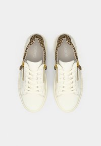 Valkoiset nahkakengät, joissa leopardikuvioinen korostus kantapäässä, kullanvärinen vetoketju ja valkoiset nauhat. Kuvioitu, pehmustettu pohja.